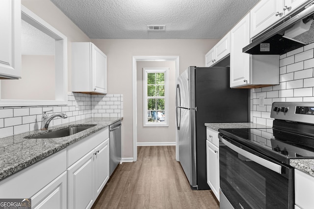 80 Corn Row Ct, Newnan, GA 30263 - kitchen featuring stainless steel appliances, under cabinet range hood, a sink, white cabinets, and a textured ceiling