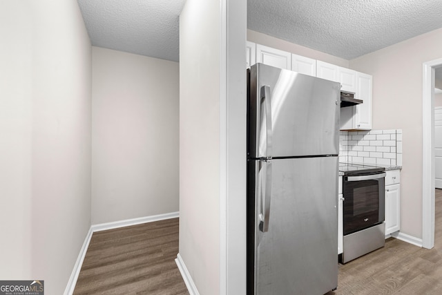 80 Corn Row Ct, Newnan, GA 30263 - kitchen with stainless steel appliances, under cabinet range hood, white cabinetry, light wood-style floors, and a textured ceiling