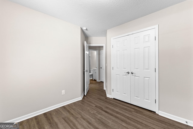 80 Corn Row Ct, Newnan, GA 30263 - unfurnished bedroom featuring dark wood finished floors, baseboards, a closet, and a textured ceiling