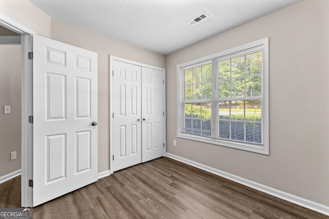 80 Corn Row Ct, Newnan, GA 30263 - unfurnished bedroom featuring wood finished floors, baseboards, a textured ceiling, and a closet