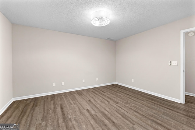 80 Corn Row Ct, Newnan, GA 30263 - spare room featuring dark wood-style floors, a textured ceiling, and baseboards