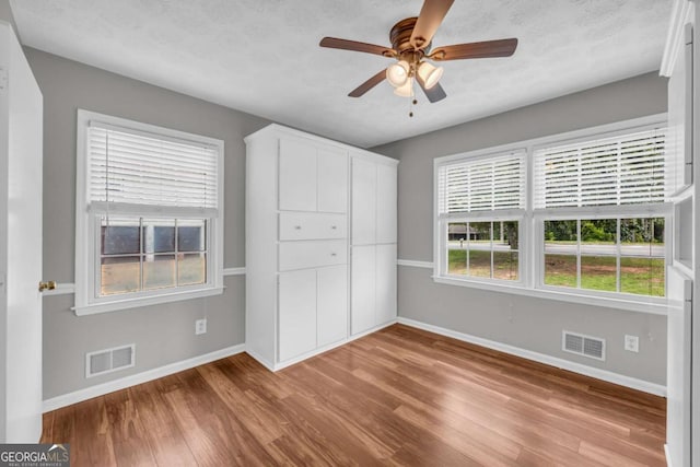 3642 S Bogan Rd, Buford, GA 30519 - unfurnished bedroom with baseboards, wood finished floors, and a ceiling fan