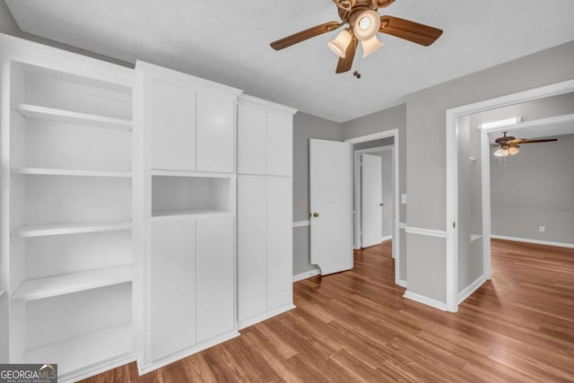 3642 S Bogan Rd, Buford, GA 30519 - unfurnished bedroom featuring wood finished floors, baseboards, and a ceiling fan