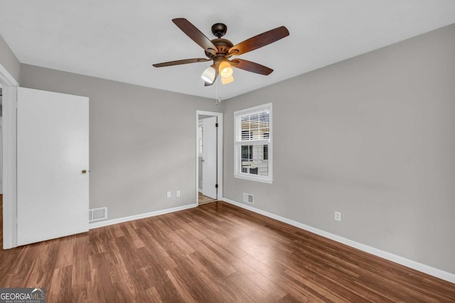 3642 S Bogan Rd, Buford, GA 30519 - unfurnished bedroom featuring baseboards, wood finished floors, and a ceiling fan