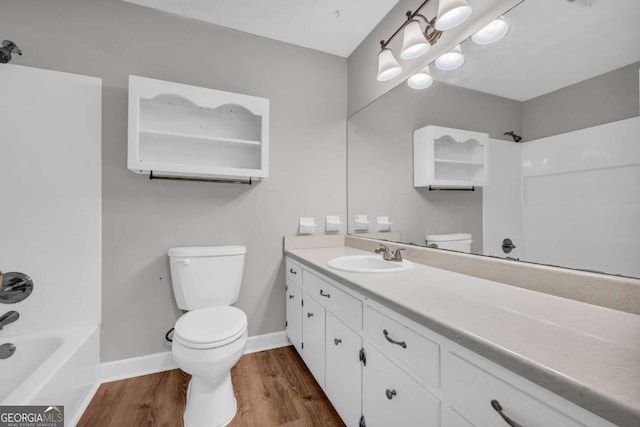 3642 S Bogan Rd, Buford, GA 30519 - bathroom featuring toilet, wood finished floors, vanity, shower / bathtub combination, and baseboards