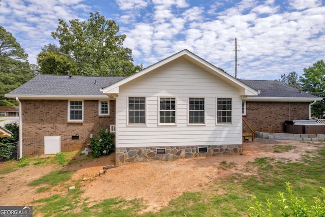 3642 S Bogan Rd, Buford, GA 30519 - back of house with crawl space, a hot tub, and brick siding