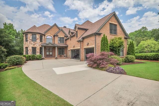4818 Moon Hollow Ct, Buford, GA 30519 - view of front of home with an attached garage, concrete driveway, a front yard, and brick siding