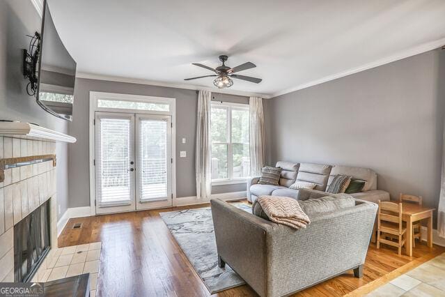 4818 Moon Hollow Ct, Buford, GA 30519 - living area with a tiled fireplace, french doors, crown molding, a ceiling fan, and baseboards