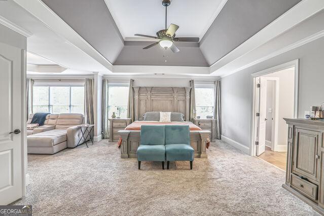 4818 Moon Hollow Ct, Buford, GA 30519 - bedroom with a tray ceiling, carpet floors, crown molding, baseboards, and a ceiling fan