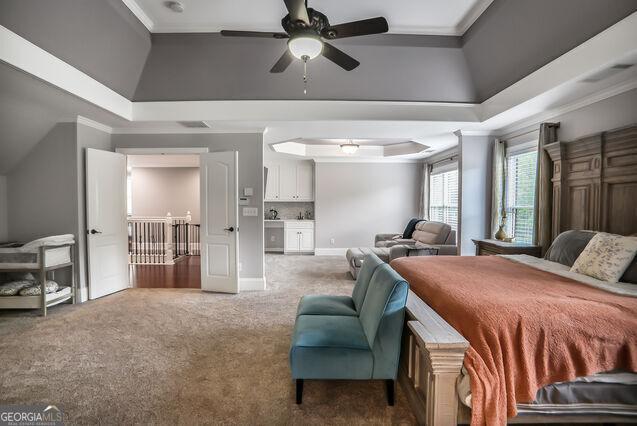 4818 Moon Hollow Ct, Buford, GA 30519 - carpeted bedroom with crown molding, a raised ceiling, baseboards, and ceiling fan
