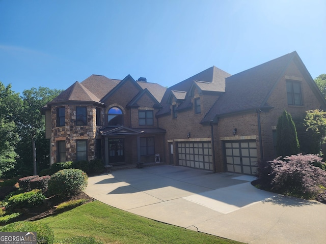 4818 Moon Hollow Ct, Buford, GA 30519 - view of front of home featuring concrete driveway, a garage, stone siding, and brick siding
