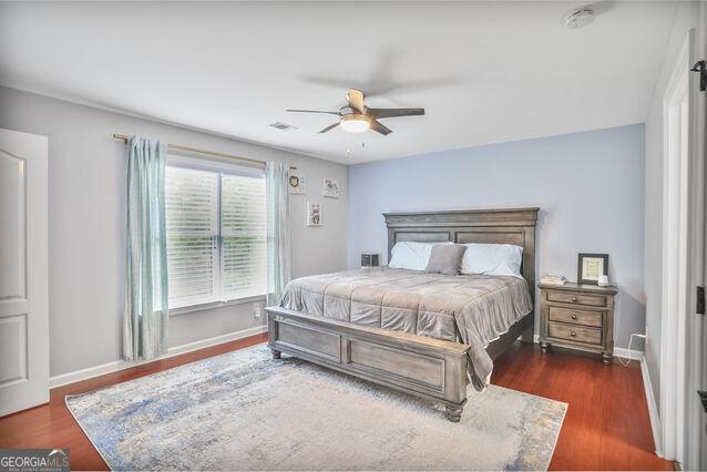 4818 Moon Hollow Ct, Buford, GA 30519 - bedroom with baseboards, wood finished floors, and ceiling fan