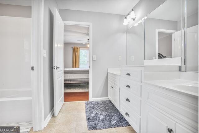 4818 Moon Hollow Ct, Buford, GA 30519 - ensuite bathroom with double vanity, tile patterned flooring, baseboards, and a ceiling fan