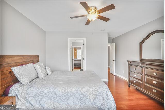 4818 Moon Hollow Ct, Buford, GA 30519 - bedroom featuring wood finished floors, baseboards, and a ceiling fan