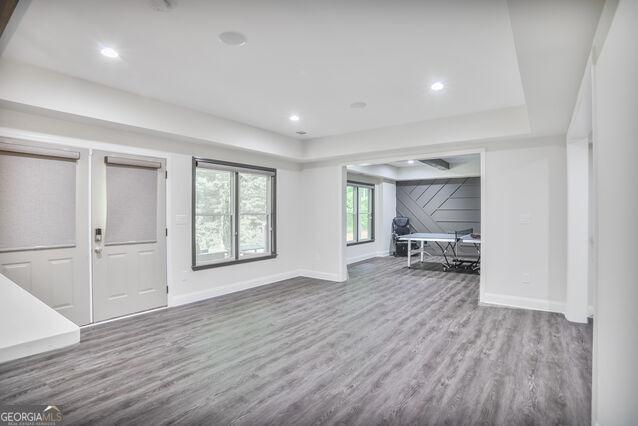 4818 Moon Hollow Ct, Buford, GA 30519 - unfurnished living room with wood finished floors, baseboards, and a raised ceiling