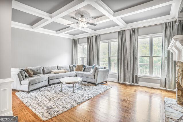4818 Moon Hollow Ct, Buford, GA 30519 - living room with coffered ceiling, ceiling fan, wood finished floors, beam ceiling, and a fireplace