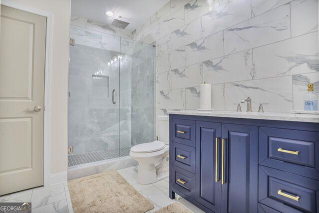 4818 Moon Hollow Ct, Buford, GA 30519 - bathroom featuring marble look tile flooring, vanity, a stall shower, and toilet