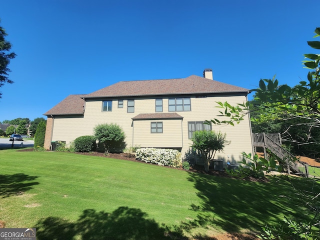 4818 Moon Hollow Ct, Buford, GA 30519 - rear view of property featuring a lawn, a chimney, stairs, and a shingled roof