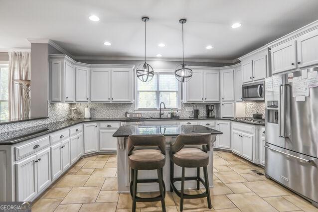 4818 Moon Hollow Ct, Buford, GA 30519 - kitchen with appliances with stainless steel finishes, backsplash, ornamental molding, recessed lighting, and a sink