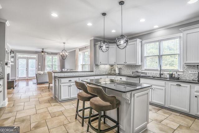 4818 Moon Hollow Ct, Buford, GA 30519 - kitchen with crown molding, backsplash, a center island, a peninsula, and recessed lighting