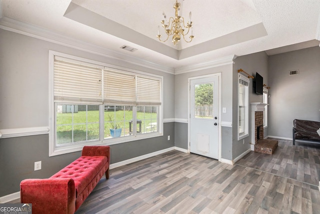 1478 Elena Dr, Mcdonough, GA 30253 - living area with a raised ceiling, a chandelier, wood finished floors, ornamental molding, and a fireplace