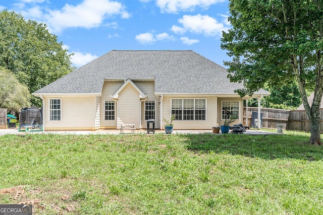 1478 Elena Dr, Mcdonough, GA 30253 - back of house featuring a trampoline, roof with shingles, and a patio