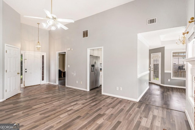 1478 Elena Dr, Mcdonough, GA 30253 - unfurnished living room featuring wood finished floors, a ceiling fan, a towering ceiling, and a chandelier