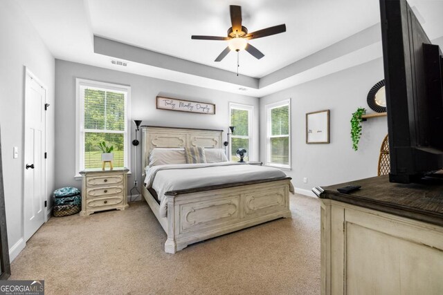 204 Dean Dr, Guyton, GA 31312 - bedroom with light colored carpet, baseboards, a tray ceiling, and ceiling fan