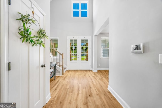 204 Dean Dr, Guyton, GA 31312 - entryway with baseboards, light wood-style flooring, stairs, and a towering ceiling