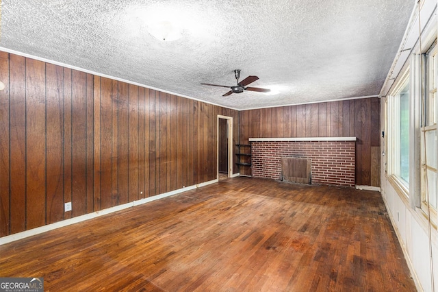 117 Chester Harris Dr, Dallas, GA 30132 - unfurnished living room with a brick fireplace, hardwood / wood-style floors, ceiling fan, a textured ceiling, and wooden walls