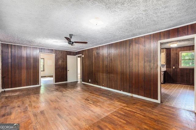 117 Chester Harris Dr, Dallas, GA 30132 - unfurnished room featuring a ceiling fan, wood walls, wood finished floors, and a textured ceiling