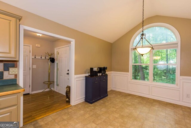 5533 Rose Ridge Ct, Flowery Branch, GA 30542 - kitchen with wainscoting, lofted ceiling, decorative light fixtures, and light flooring