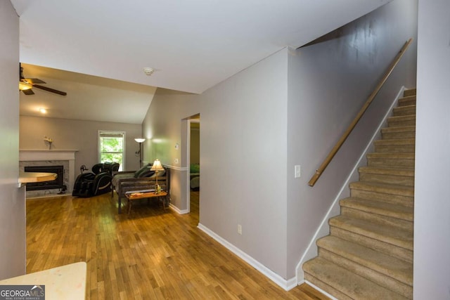 5533 Rose Ridge Ct, Flowery Branch, GA 30542 - living area featuring wood finished floors, stairway, ceiling fan, a fireplace, and baseboards