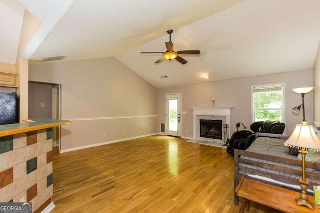 5533 Rose Ridge Ct, Flowery Branch, GA 30542 - living room with a high end fireplace, light wood-style flooring, vaulted ceiling, plenty of natural light, and ceiling fan