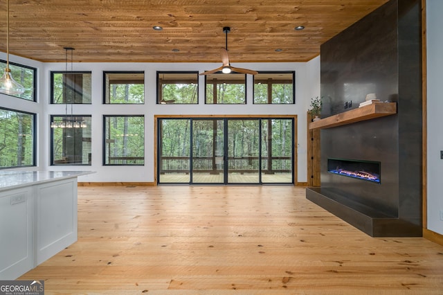 221 Goldmine Rd, Morganton, GA 30560 - unfurnished living room with wood ceiling, a glass covered fireplace, baseboards, a towering ceiling, and light wood-style flooring