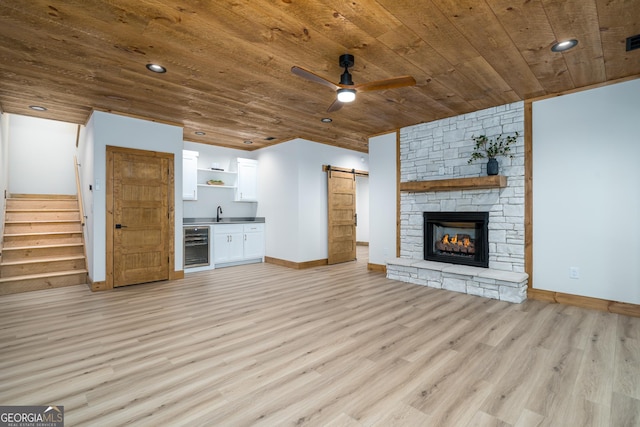 221 Goldmine Rd, Morganton, GA 30560 - unfurnished living room featuring wooden ceiling, a barn door, light wood finished floors, beverage cooler, and ceiling fan