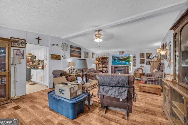 3085 Pea Ridge Rd, Cornelia, GA 30531 - living room with light wood-style floors, a textured ceiling, ceiling fan, and a warm lit fireplace