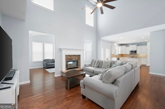 130 Bevington Ln, Woodstock, GA 30188 - living room with ceiling fan, a towering ceiling, healthy amount of natural light, dark wood finished floors, and a fireplace