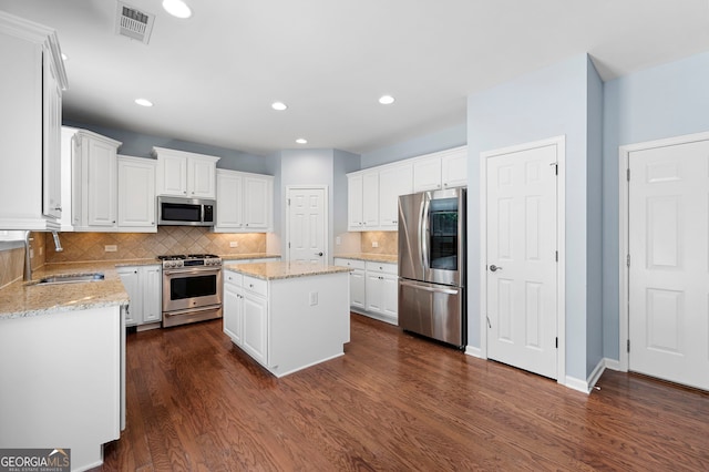 130 Bevington Ln, Woodstock, GA 30188 - kitchen with appliances with stainless steel finishes, a sink, dark wood finished floors, white cabinetry, and recessed lighting