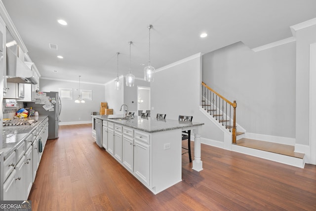 132 Shellbark Dr, Mcdonough, GA 30252 - kitchen featuring a breakfast bar, crown molding, an island with sink, white cabinetry, and dark wood-style flooring