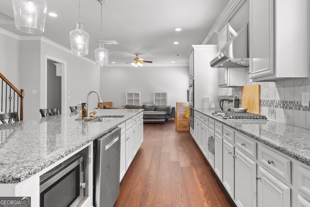 132 Shellbark Dr, Mcdonough, GA 30252 - kitchen featuring stainless steel appliances, ceiling fan, ornamental molding, wall chimney range hood, and white cabinets