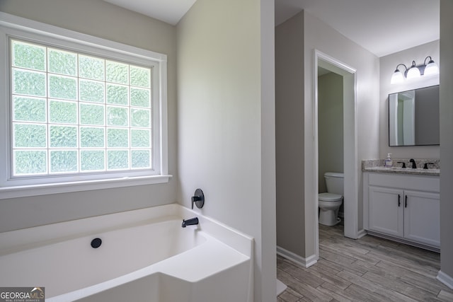 520 Campbell Rd, Cedartown, GA 30125 - bathroom with vanity, toilet, a bath, wood finished floors, and baseboards