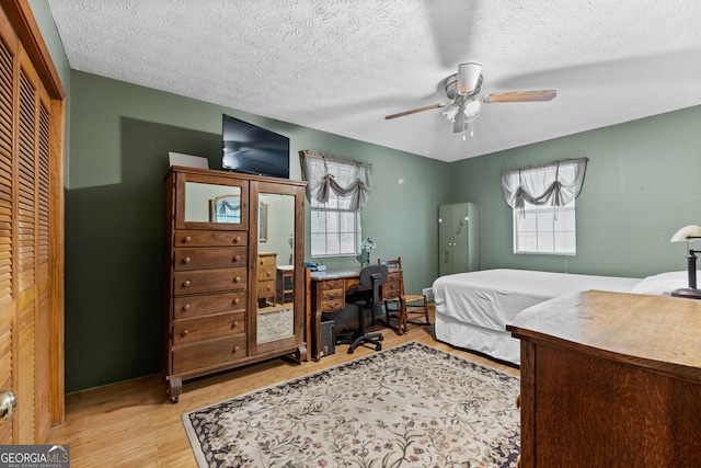 349 Campground Rd, Mcdonough, GA 30253 - bedroom featuring wood finished floors, a desk, a textured ceiling, a ceiling fan, and a closet