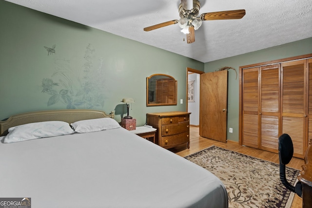 349 Campground Rd, Mcdonough, GA 30253 - bedroom featuring light wood-style flooring, a closet, a textured ceiling, and a ceiling fan