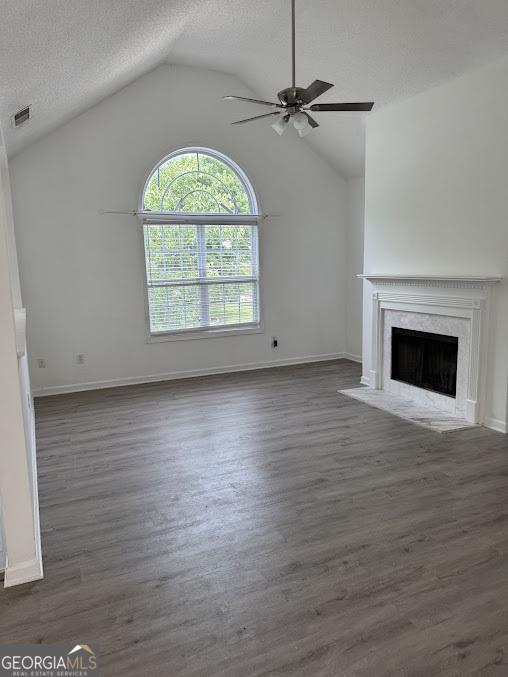 5709 Newnan Cir, Austell, GA 30106 - unfurnished living room with ceiling fan, a premium fireplace, lofted ceiling, wood finished floors, and baseboards