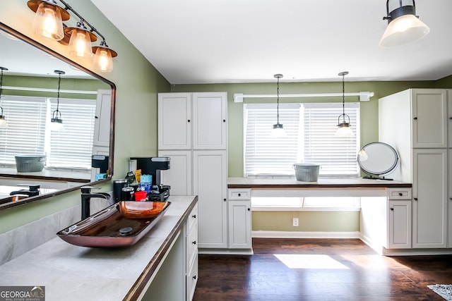 387 Colvin Dr, Locust Grove, GA 30248 - kitchen with dark wood-style flooring, pendant lighting, white cabinetry, baseboards, and a sink