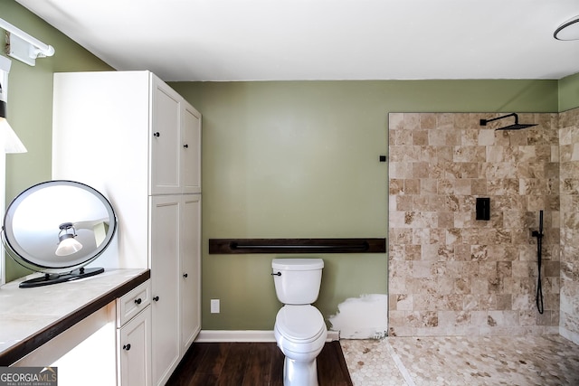 387 Colvin Dr, Locust Grove, GA 30248 - full bath with vanity, a tile shower, wood finished floors, toilet, and baseboards
