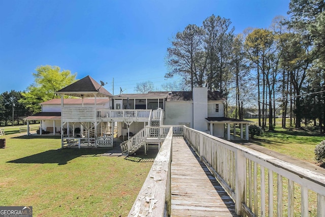 387 Colvin Dr, Locust Grove, GA 30248 - back of property with a yard, a sunroom, stairway, and a shingled roof
