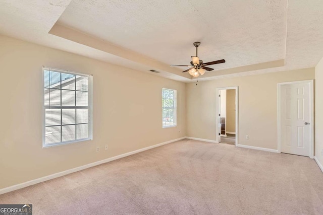 484 Cathedral Dr, Mcdonough, GA 30253 - unfurnished bedroom with a tray ceiling, baseboards, light carpet, a textured ceiling, and ceiling fan
