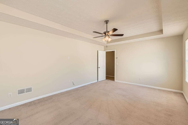484 Cathedral Dr, Mcdonough, GA 30253 - spare room with a tray ceiling, ceiling fan, baseboards, and carpet